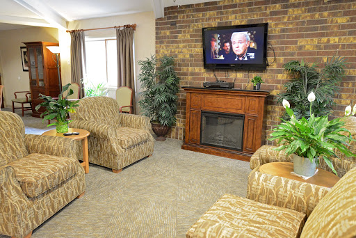 A cozy living room featuring comfortable seating, a television for entertainment, and decorative plants.