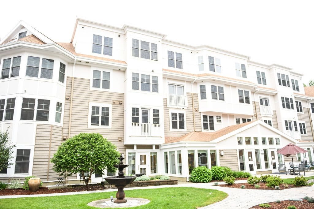 A multi-story residential building with a landscaped courtyard and a fountain.