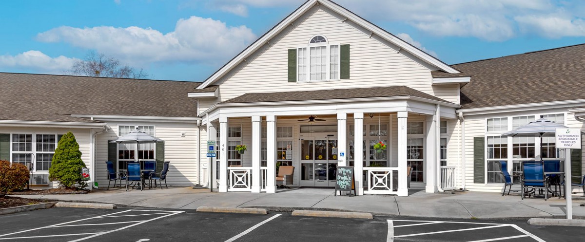 A small storefront with a gabled roof and a parking area in front.
