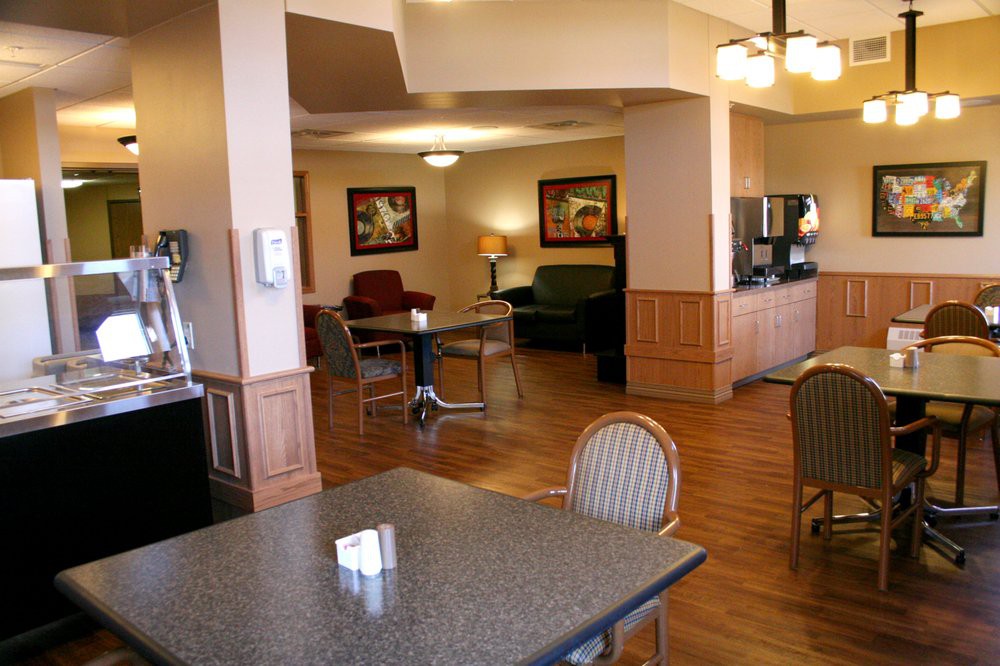 A cozy hotel lobby with seating and a coffee station.