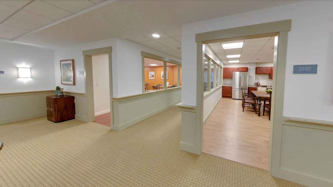 A modern office interior featuring a hallway and a conference room.