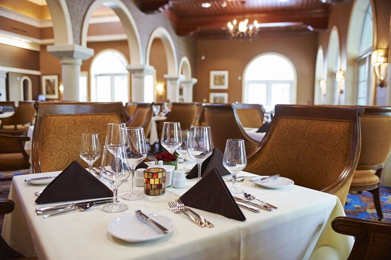 An elegantly set table in a fine dining restaurant with neatly arranged glassware and cutlery.
