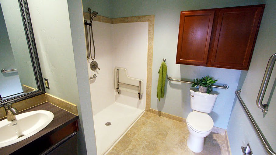A modern accessible bathroom with a walk-in shower and grab bars.