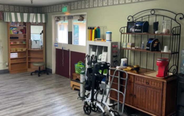 A healthcare facility room with medical equipment and supplies, including a wheelchair and walker.