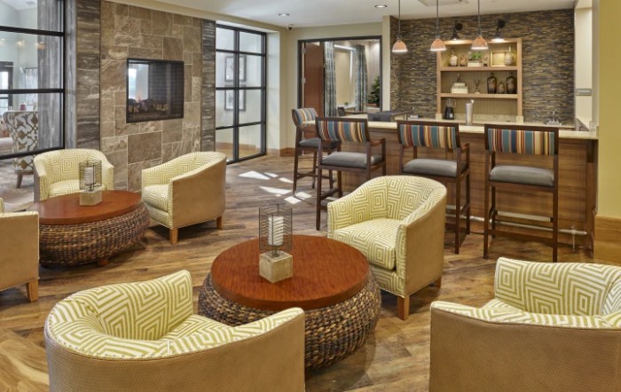 A cozy lounge with modern furniture and a bar area.
