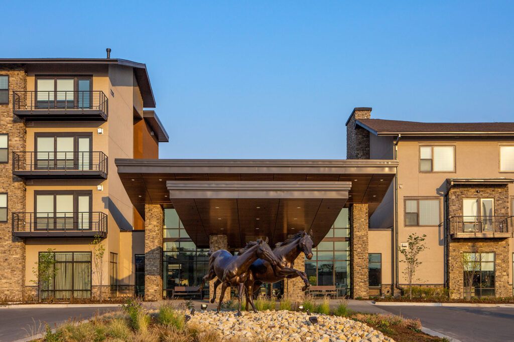 A modern building entrance featuring a prominent horse sculpture.