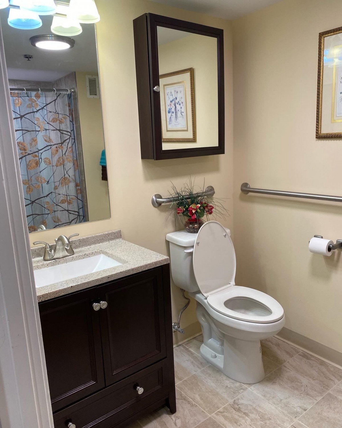 A neatly arranged modern bathroom with a toilet, sink, and wall art.