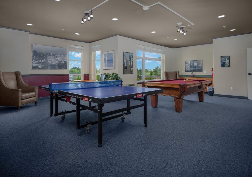 A spacious game room featuring a ping pong table and a pool table.