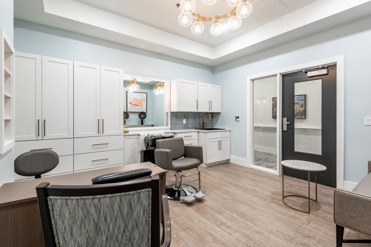 A modern hair salon interior featuring sleek white cabinetry, stylish chairs, and elegant lighting.