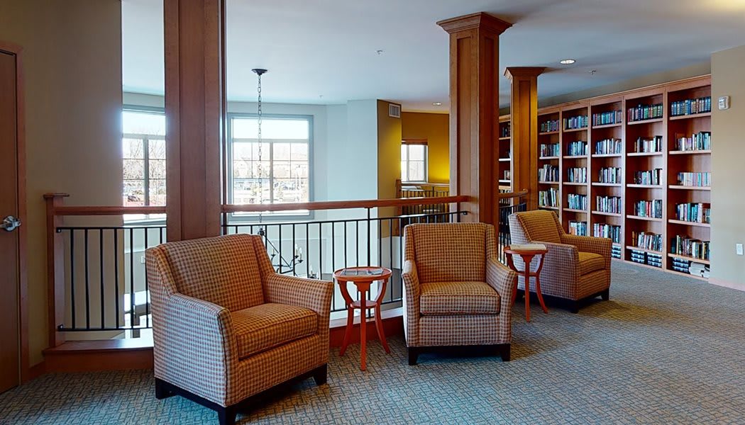 A cozy library interior with comfortable seating and wooden bookshelves.