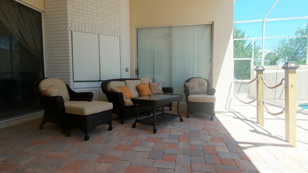 A cozy patio setup with rattan furniture and cushioned seating.