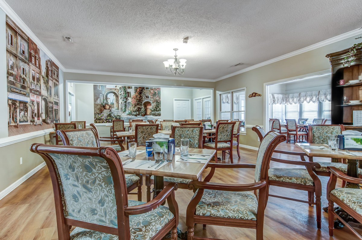 A cozy dining room setup with elegant wooden chairs and tables, well-lit by chandeliers.