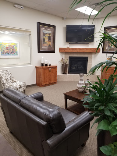 A cozy living room featuring a leather sofa, a coffee table, and decorative artwork on the walls.