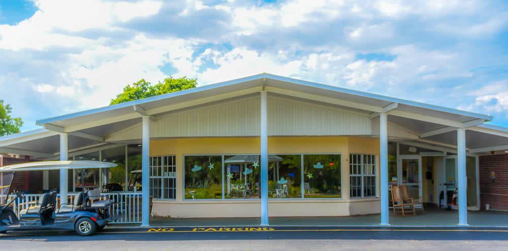A small storefront building with large windows on a cloudy day.