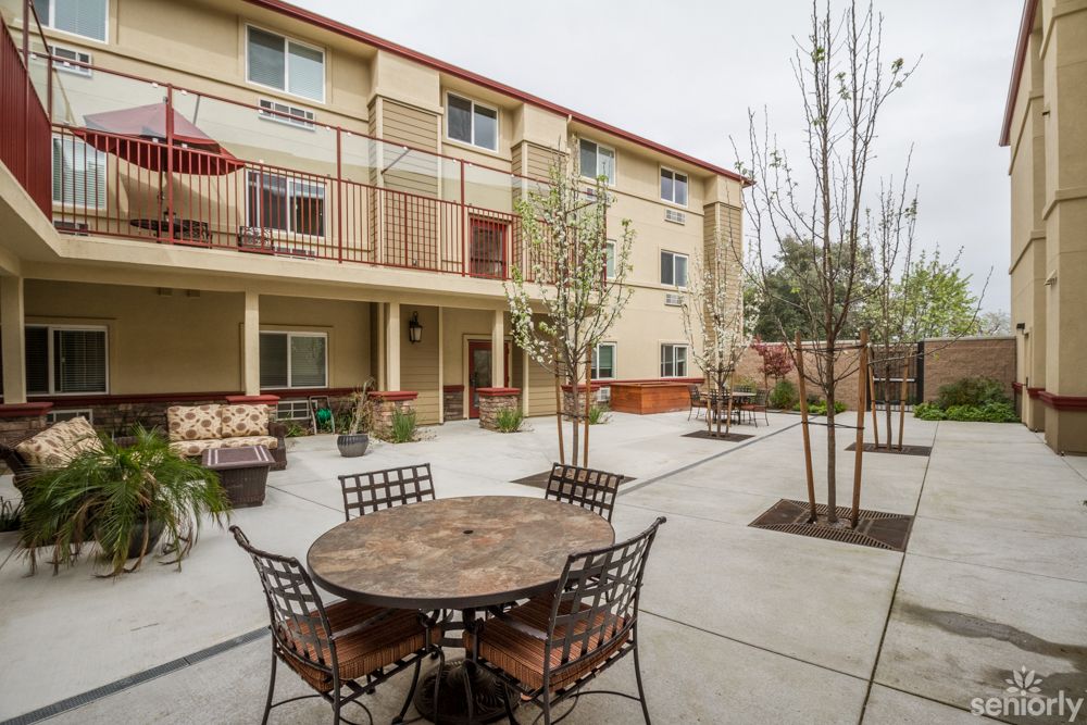 Outdoor courtyard area with tables and chairs in an apartment complex.