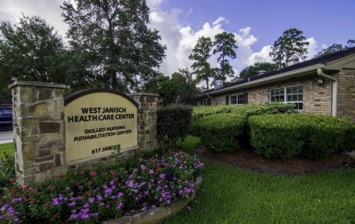 West Jarnich Healthcare Center with surrounding greenery and flowers.