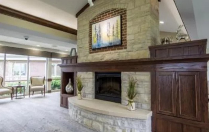 A modern living room featuring a stone fireplace with artwork above it.