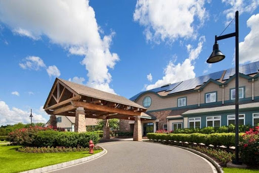 A welcoming entrance to a residential building under a blue sky.