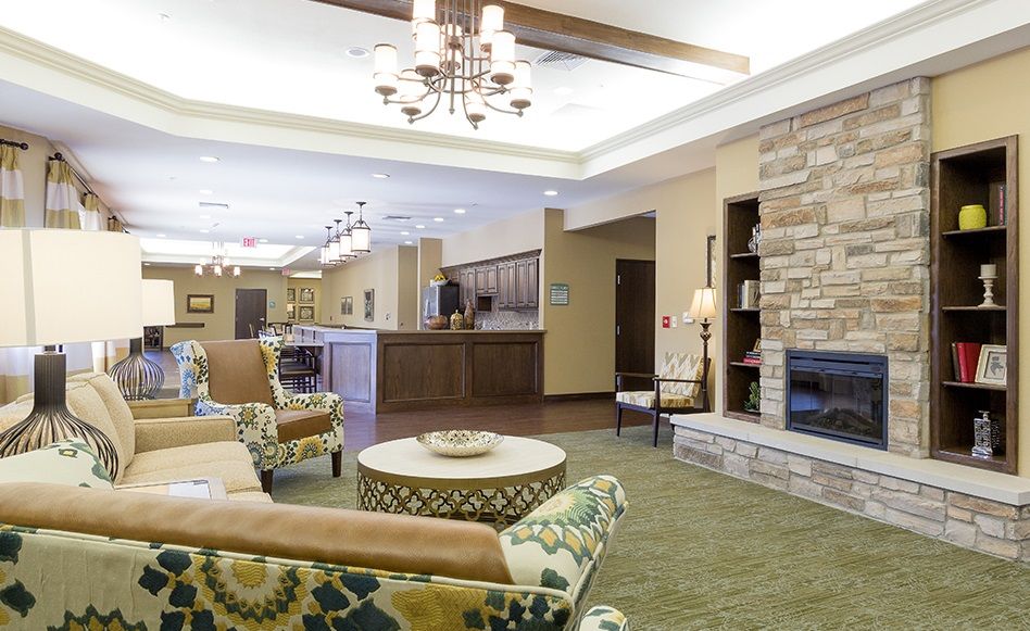 A cozy and well-decorated hotel lobby with comfortable seating, a stone fireplace, and a chandelier.