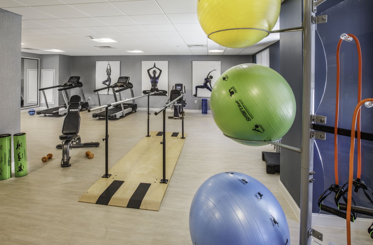 A fitness center featuring exercise balls, treadmills, and other workout equipment.