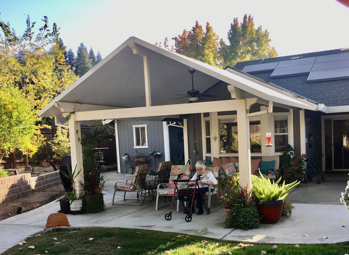 A cozy outdoor patio area with seating and surrounded by greenery.