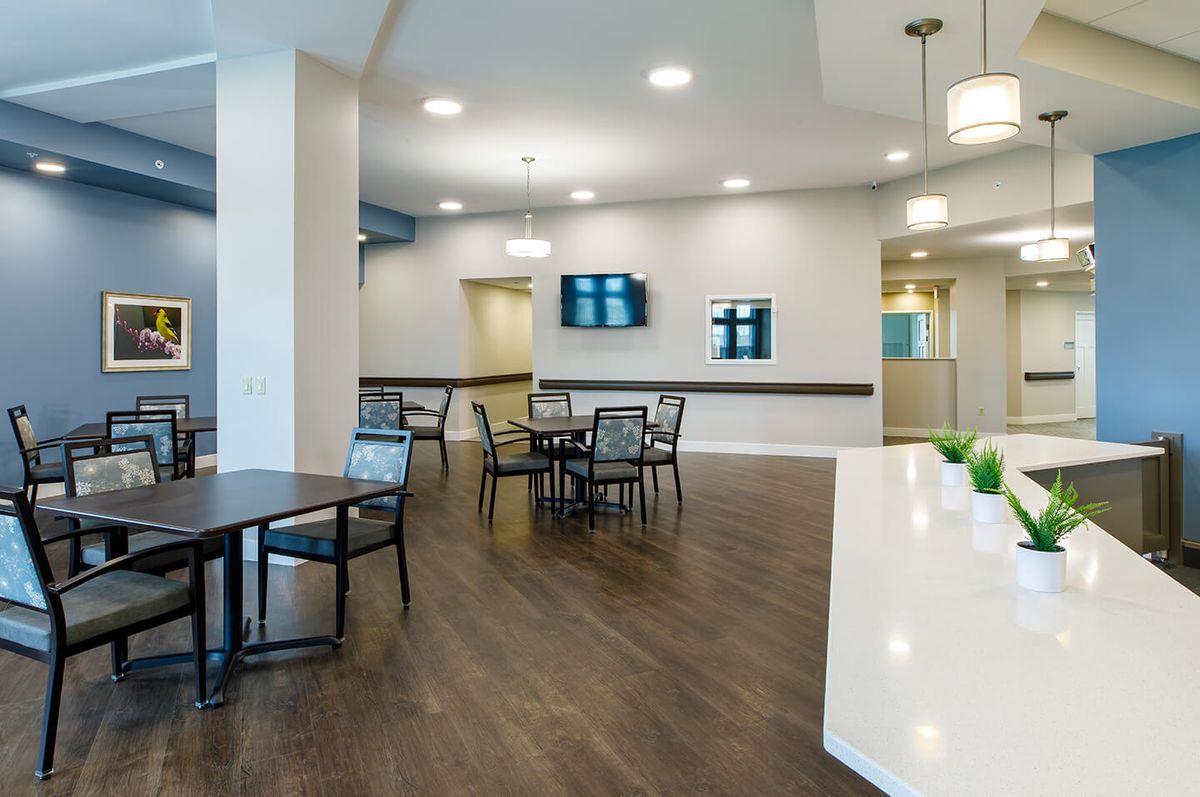 A modern interior space featuring tables and chairs, with decorative wall elements and contemporary lighting.