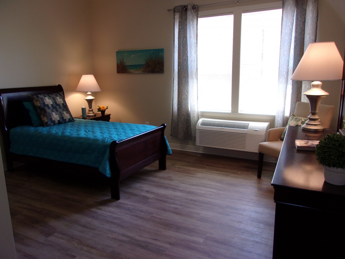 A cozy bedroom with a large window, comfortable bed, and tasteful decor.