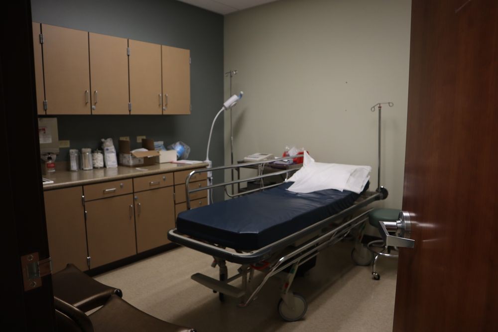 A small examination room with a medical bed and essential healthcare equipment.