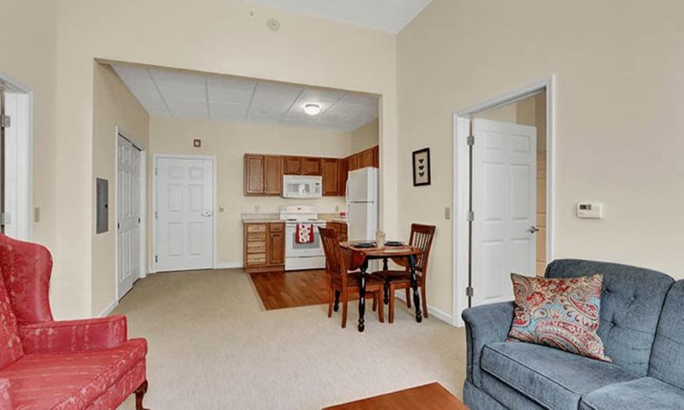 A cozy apartment featuring an open-plan living room with a kitchen and dining area.