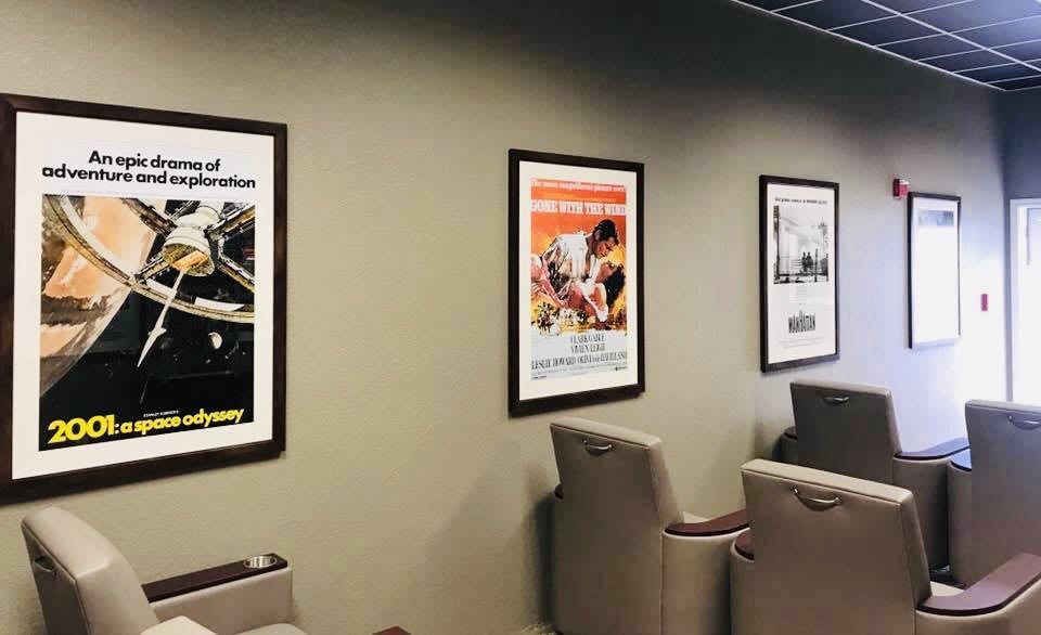 A waiting area with framed posters on the wall and comfortable chairs.