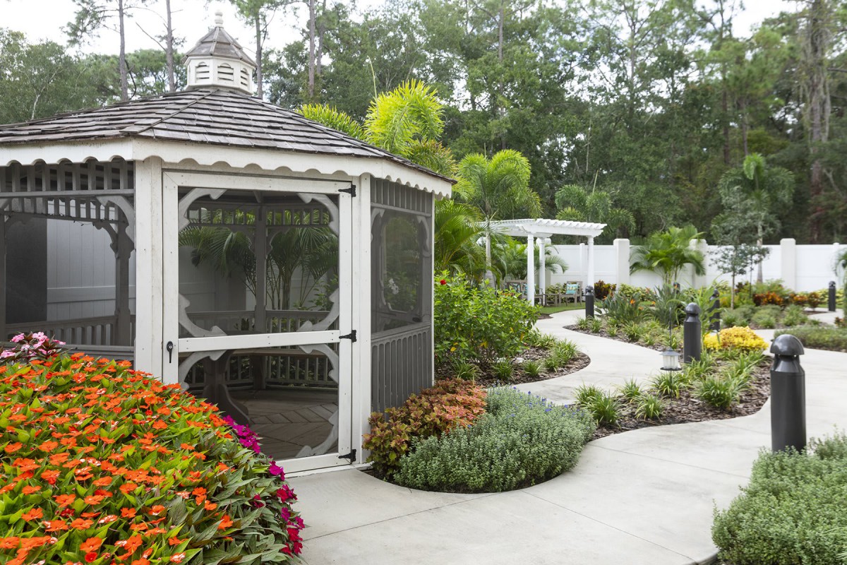 A serene garden with a gazebo, colorful flowers, and a winding pathway.