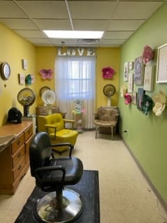 A cozy salon room with colorful walls and eclectic decor.