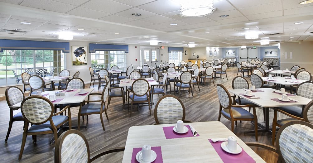 A spacious dining room with neatly arranged tables and chairs, prepared for dining.