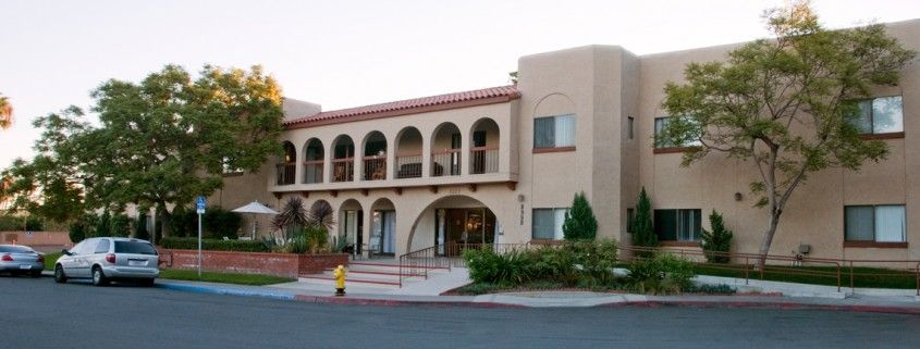 A two-story building with a Mediterranean-style design featuring arches and a stucco exterior.