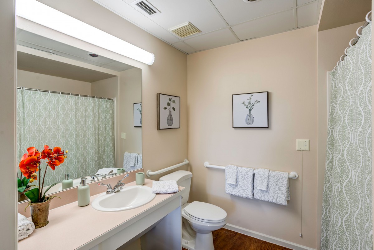 A clean and neatly organized bathroom with modern fixtures and simple decor.