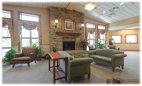 A cozy lobby with a stone fireplace, comfortable seating, and large windows letting in natural light.