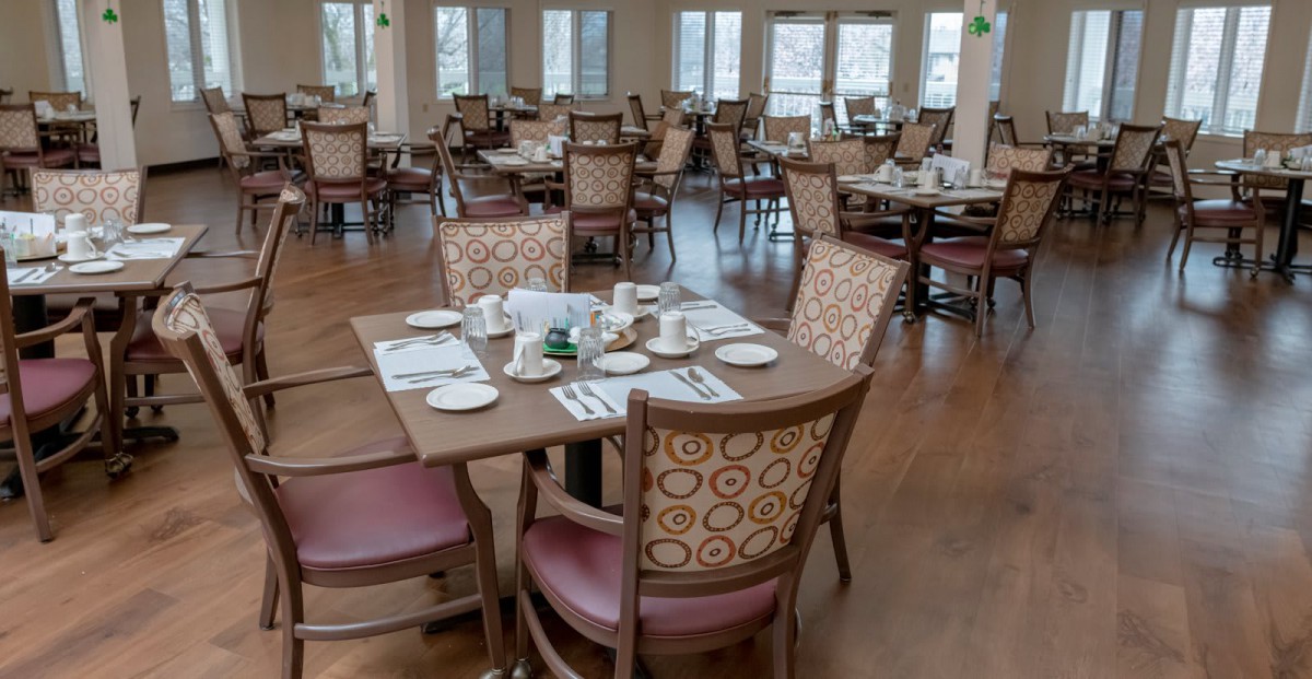 An empty restaurant dining area with neatly set tables and chairs.