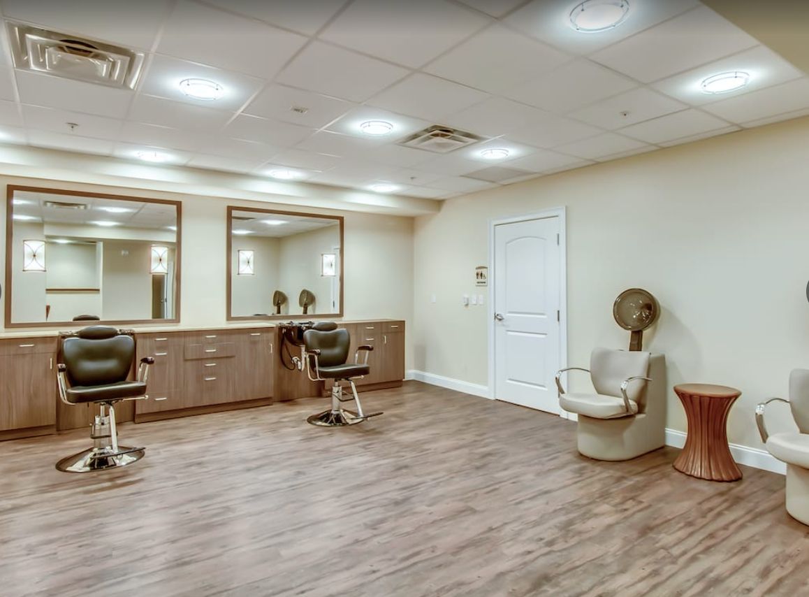 A modern salon interior with styling chairs, mirrors, and a hairdryer station.