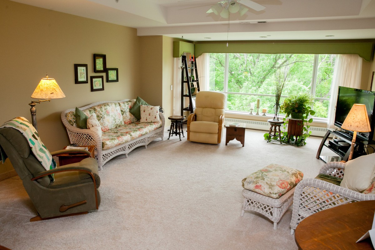 A cozy living room with comfortable furniture and a large window overlooking greenery.