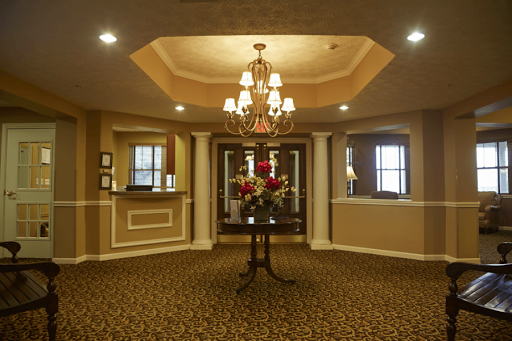 An elegant lobby featuring a chandelier and floral decor.