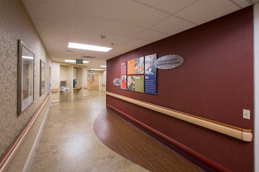 A well-lit hospital hallway featuring colorful informational posters on the wall.