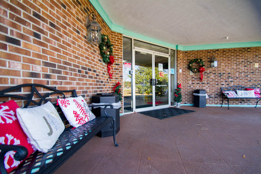 A festive entrance adorned with holiday wreaths and a welcoming bench.