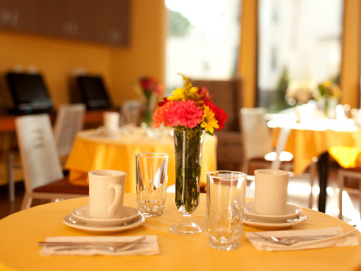 A beautifully arranged dining table with vibrant flowers and elegant glassware.