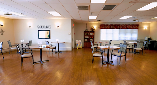 A spacious and inviting dining area with tables and chairs, designed for comfort and community gatherings.