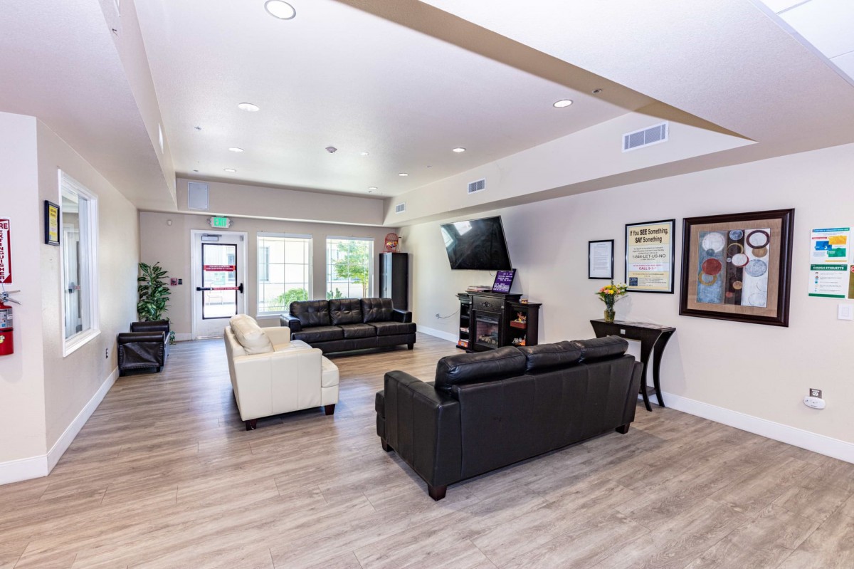 A modern living room with sofas and a wall-mounted television.