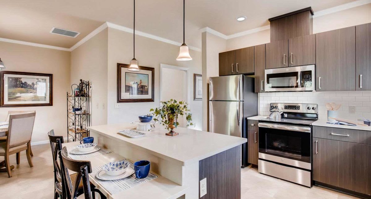 A modern kitchen with stainless steel appliances and an island counter.
