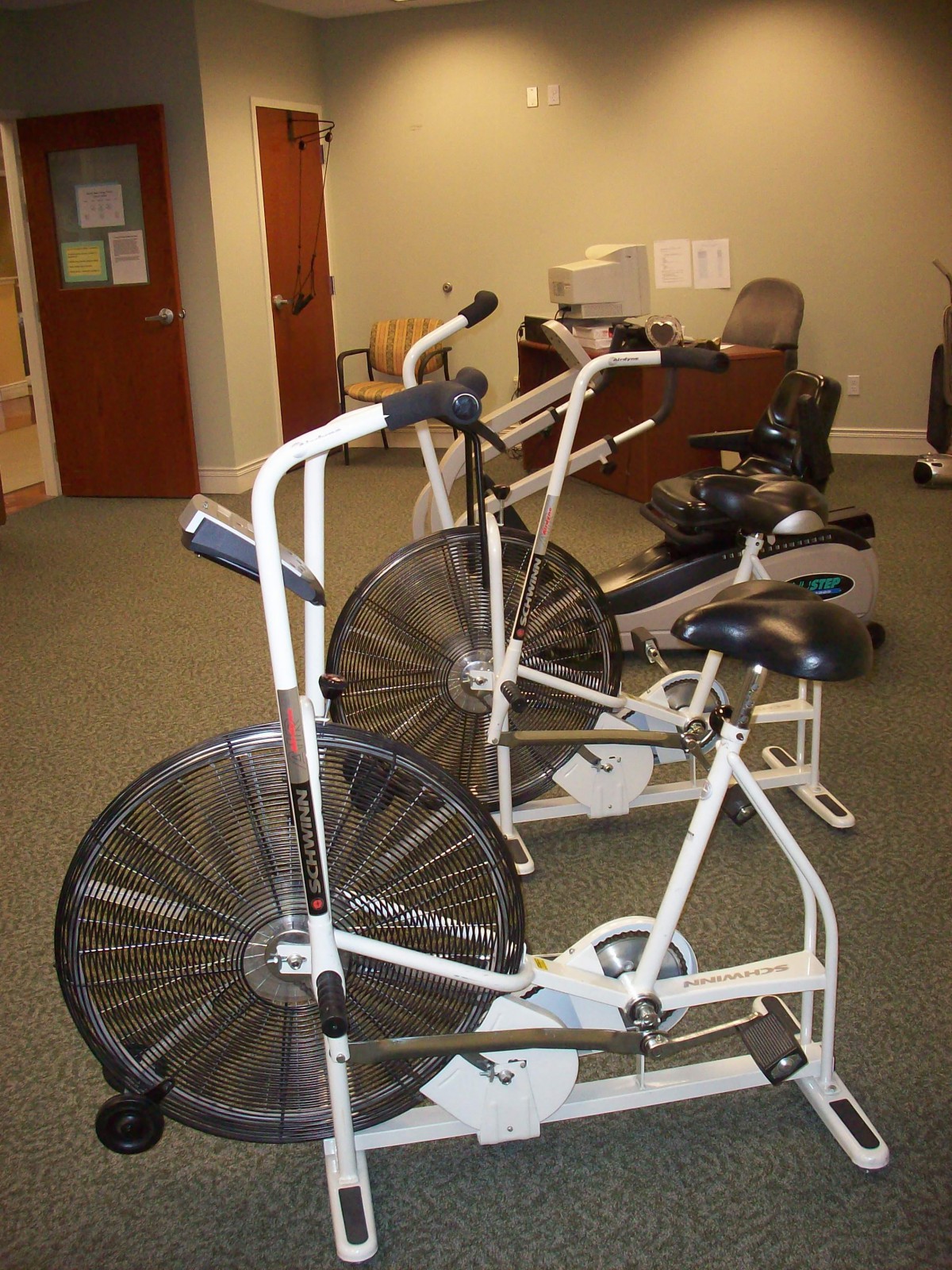 A small gym room featuring multiple exercise bikes lined up for indoor cycling sessions.