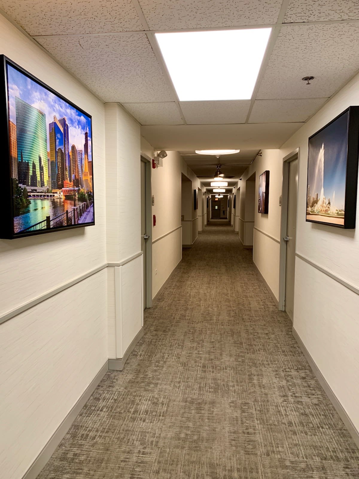 A well-lit hallway with artwork displayed on the walls.