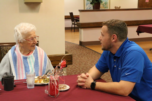 An engaging conversation between a young man and an elderly woman over dinner.