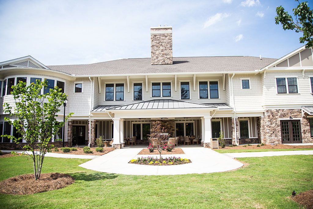 A luxurious two-story house with a well-maintained lawn and modern architectural design.